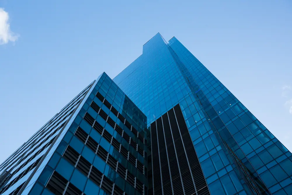Glass office tower against a blue sky